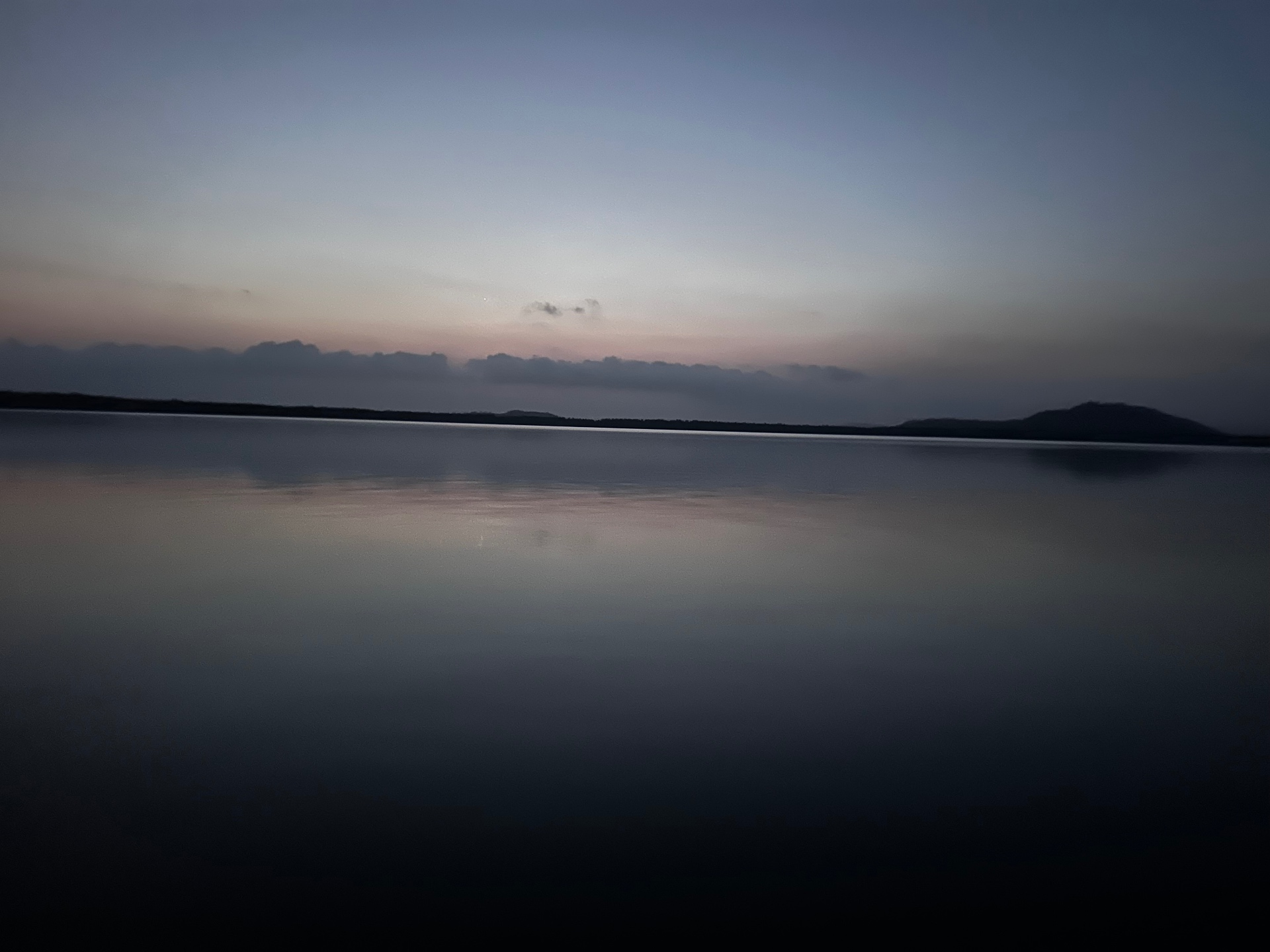 A still lagoon at dawn reflecting the sky