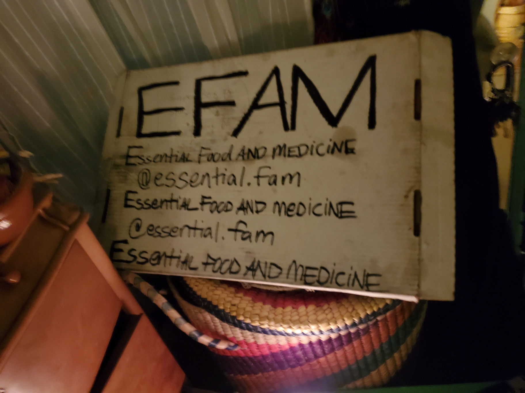 Handmade EFAM sign reading Essential Food and Medicine