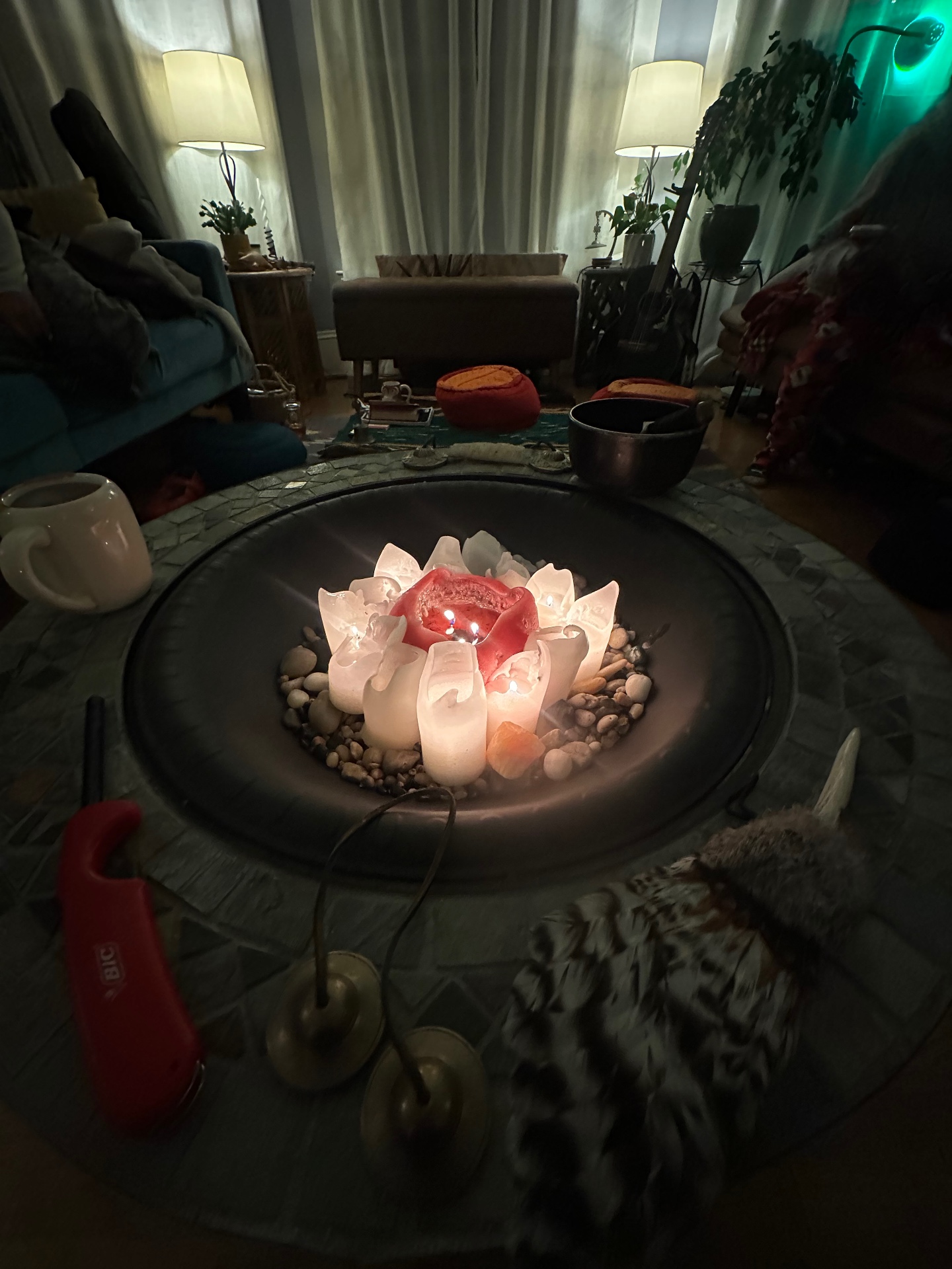 A lotus candle burning on a simple altar