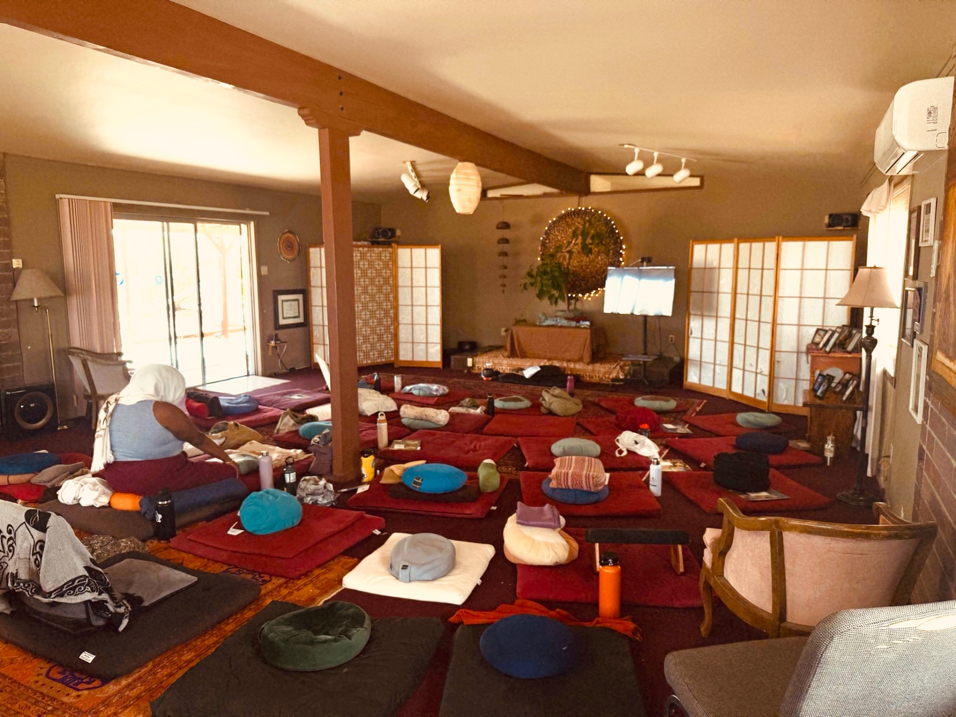 An empty meditation hall with cushions arranged in rows